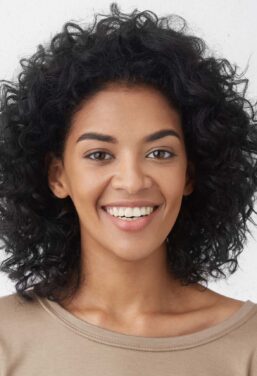 Woman smiles broadly, pleased with her Invisalign in NYC.