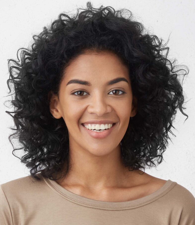 Woman smiles broadly, pleased with her Invisalign in NYC.